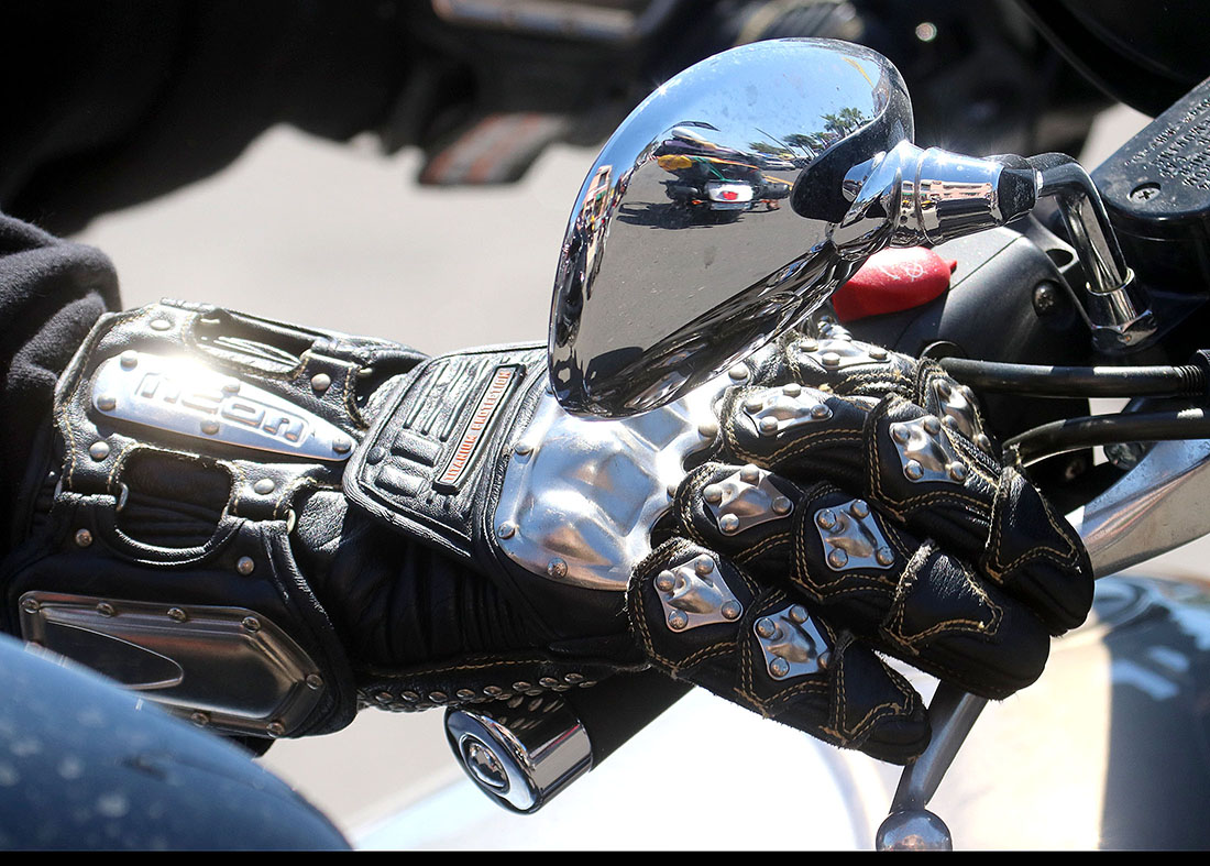 A biker with some serious gloves rides his bike down Main Street in Daytona Beach Wednesday  March 15, 2017 as Bike Week races toward it's final weekend. [News-Journal/JIM TILLER ]