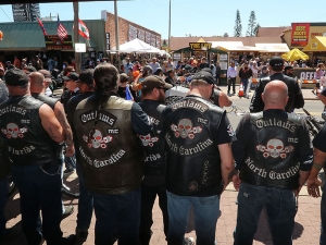 Members of the Outlaws Motorcycle Club stand shoulder to shoulder infront of Dirty Harry's bar on Main Street as Bike Week 2017 heads into it's last weekend in Daytona Beach Saturday March 18,  2017. [News-Journal/JIM TILLER ]